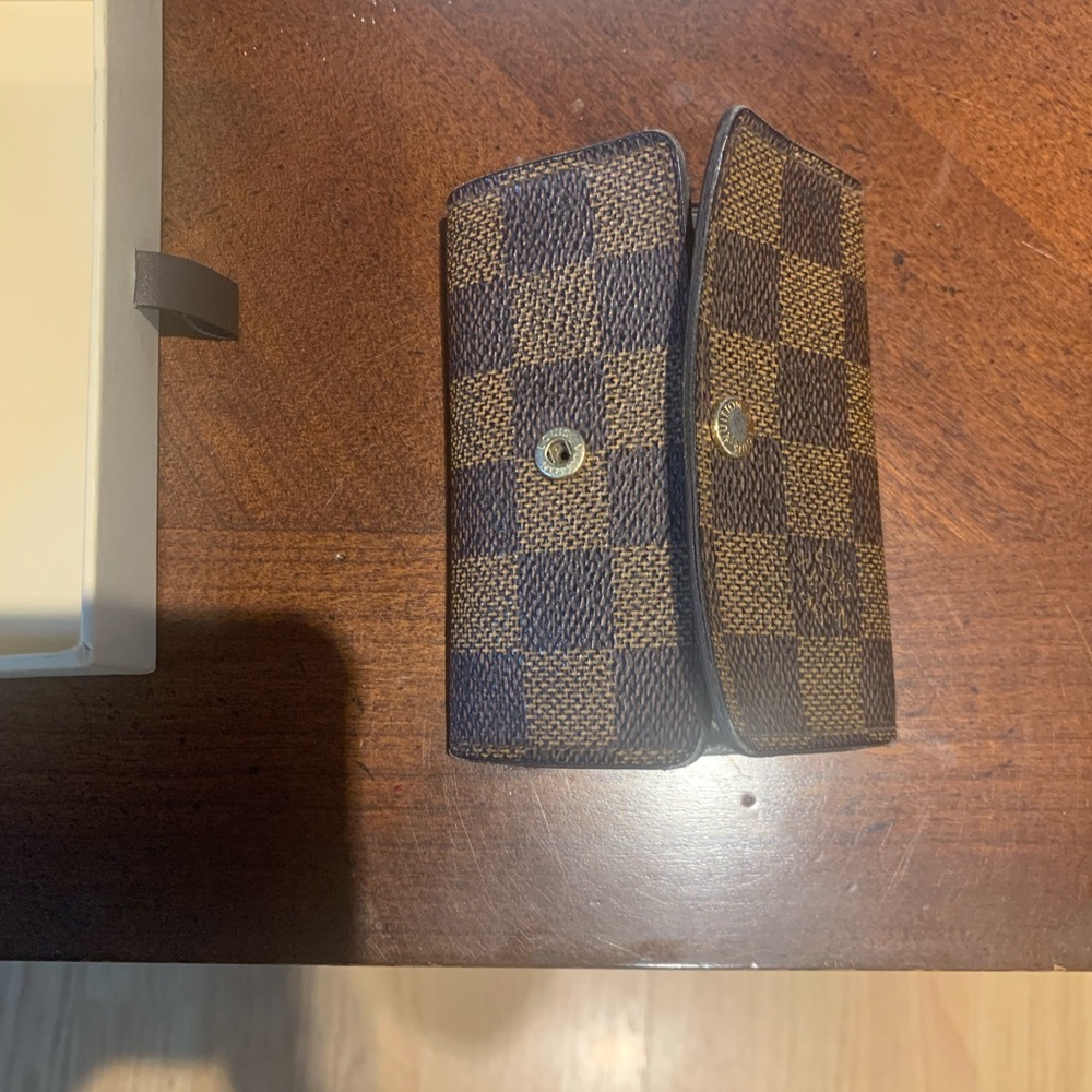 Two key rings on each side is missing. Has a hidden pocket under it for cards.